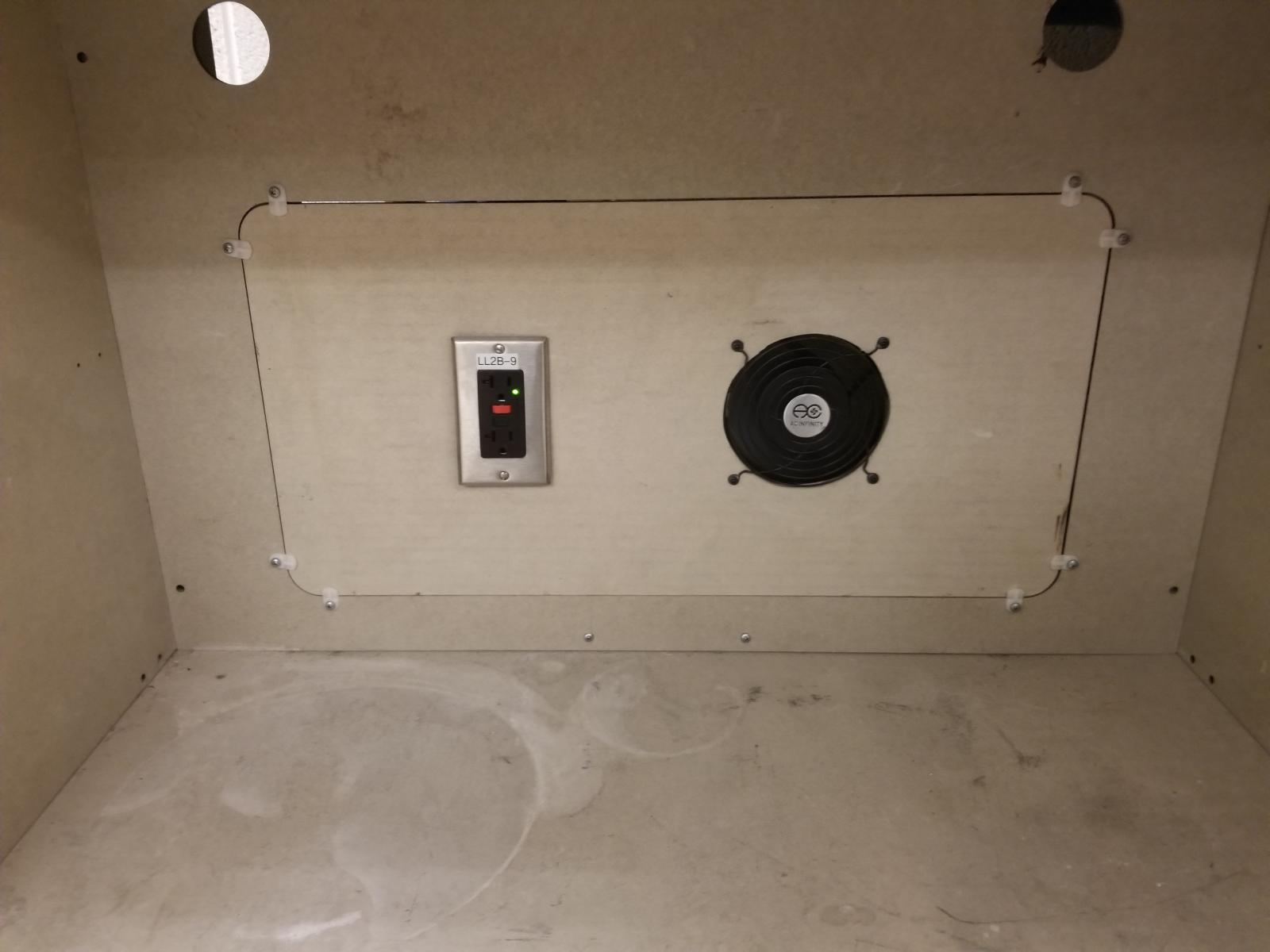 Outlet and cooling fan installed in fume hood.